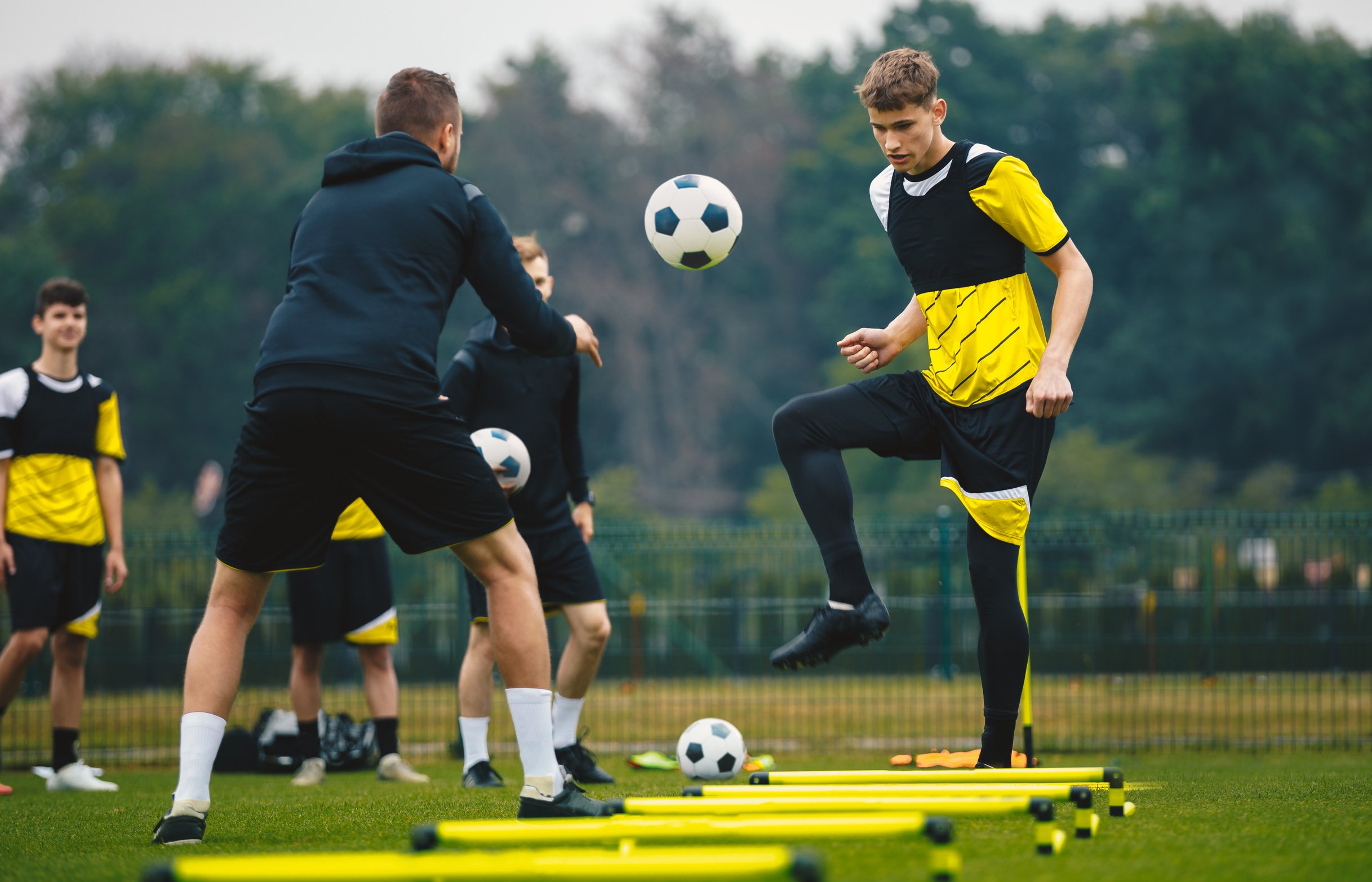 Male Footballers Training with Coach in the Stadium